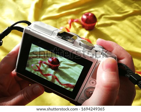 A camera taking a picture of a red apple.