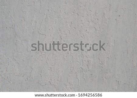 Textured background in gray with small cracks. Old, dirty paint silver color with a heterogeneous convex structure.