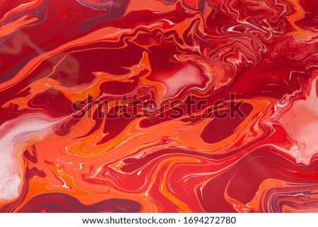 Liquid red and white marbling paint background. Fluid painting abstract texture, art technique. Colorful mix of acrylic vibrant colors.