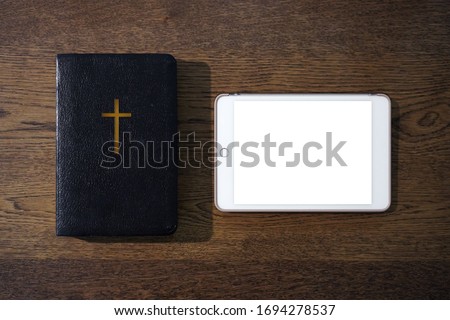 Top view of holy bible with blank tablet on wooden table, Church online Sunday  services new normal concept, Home church during quarantine coronavirus Covid-19, Study bible worship online concept