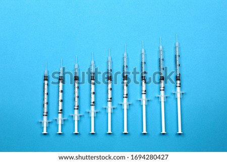 Medical syringe on a blue background. Medical instruments for vaccination and treatment.