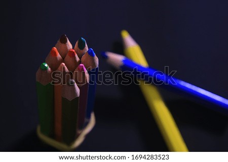 colored pencils on a black background - school time