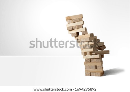 Wooden block tower game collapses isolated on white background with copy space