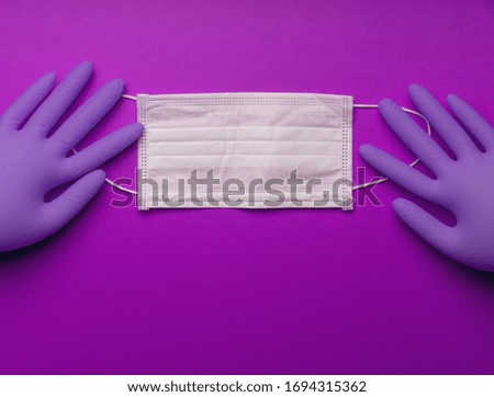 Pair of latex medical gloves on purple background. Protection concept. COVID-19. Coronavirus. Facial masks and gloves. Epidemic background. Quarantine background. thanks to the doctors