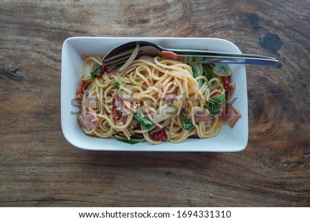 Stock Photo - Spaghetti spicy bacon with hot basil on wooden table