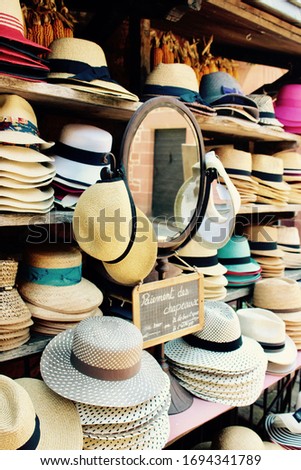 Pretty straw hats in France with "Pay for the hats at the bar or at the store" sign  and vintage oval mirror (2017)
