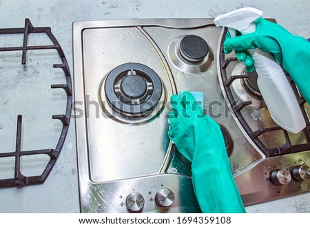 washing the gas stove after cooking with gloves