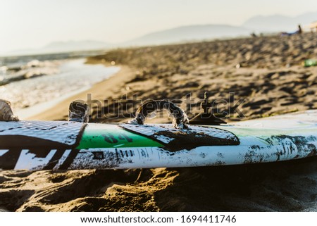 Green-white surfboard on the beach