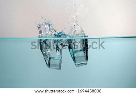 Bubbles forming in  water after ice cubes are dropped 