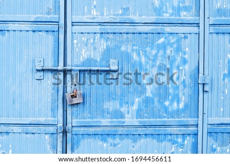 Grunge metal background. Blue paint garage door. Rusty padlock texture. Empty copy space corrugated metal sheet pattern.