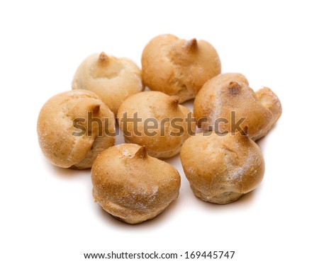 Cake profiteroles stacked on a white background. Shallow depth of field.