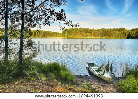 Pine forests on the shore of a taiga lake. Early autumn, the sun and ringing silence. Royalty-Free Stock Photo #1694461393