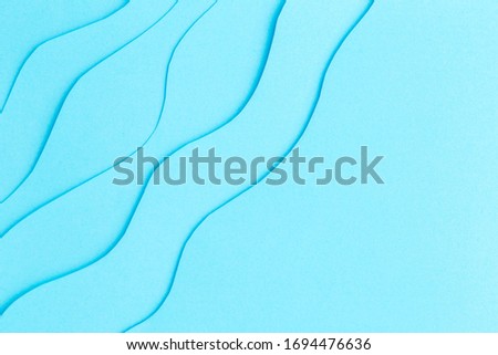 blue background with waves of paper abstraction, free space for text