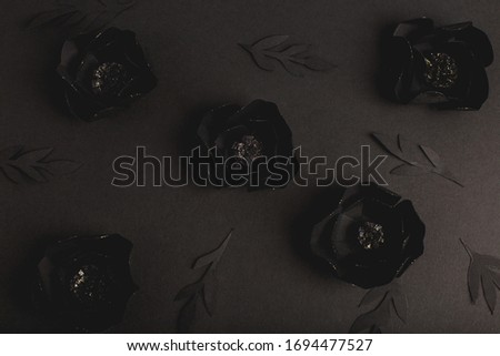 black background with a beautiful gold glittering flowers made of paper, top view