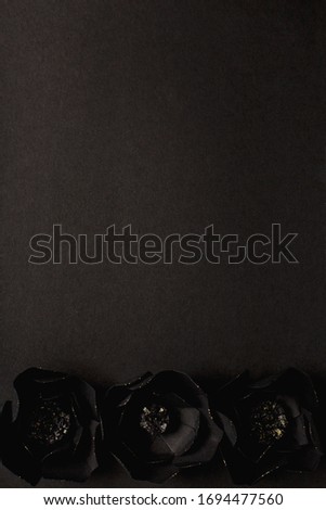black background with a beautiful gold glittering flowers made of paper, top view, free space for text