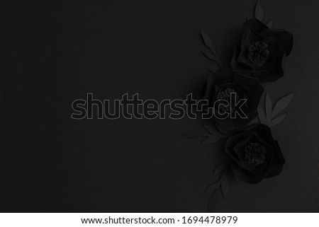 black background with three flower made of paper, top view, horizontal, free space for text