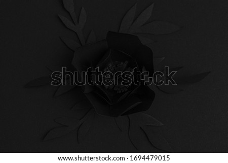 black background with a big flower made of paper, top view, free space for text