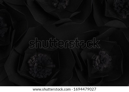 black background with big flowers made of paper, top view, horizontal, macro