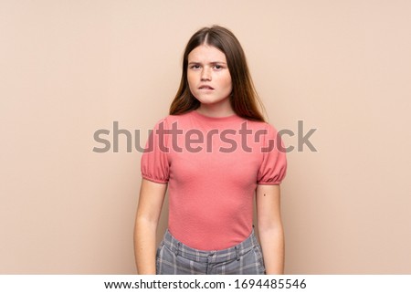 Ukrainian teenager girl over isolated background having doubts and with confuse face expression
