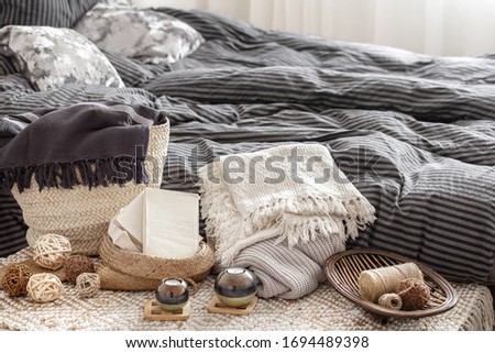 Decorative items in a cozy home interior. Wicker straw large bag, and decorative elements. Concepts of style and comfort. Royalty-Free Stock Photo #1694489398