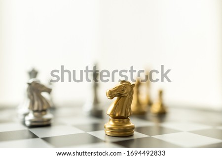 Sport board game, Business and planning concept. Closeup of knight chess piece on chessboard with other pieces.