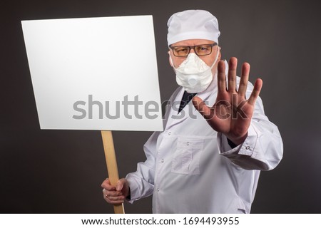 A doctor in a protective mask makes a restraining gesture. Doctor with a poster in hands. Place for the label. Medical restrictions. Medical quarantine. A call to follow the recommendations of doctors