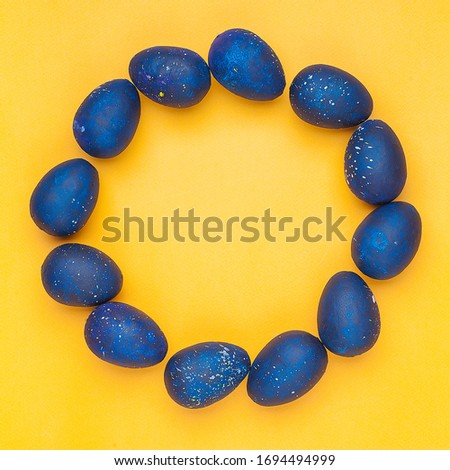 Blue eggs on a yellow background. Circle shape. trendy Easter egg of color of the year-classic blue, Top view. Flat lay. The object in the center of the photo.