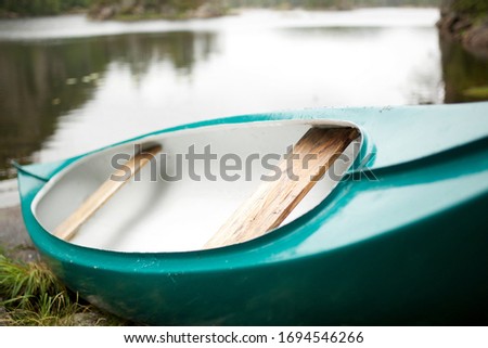Canoe laying next to lake side 