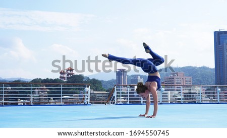 
Beautiful flexible girl professional circus acrobat performer handstand, gymnastic bridge, backbend position, graceful woman on cruise liner, sports model on blue background, ship, Asian temple, city