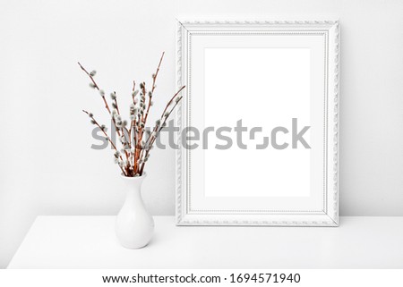 White vase and frame with copy space on a white table