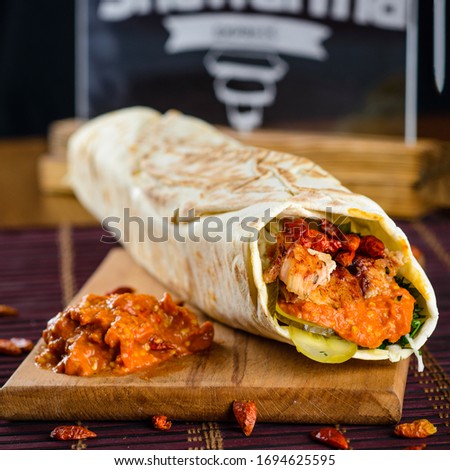 Burritos wraps with grilled meat and vegetables - peppers, tomatoes and corn. Mexican food, spicy shawarma with chili pepper