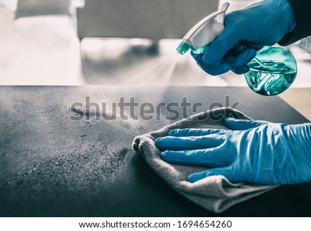 Surface sanitizing against COVID-19 outbreak. Home cleaning spraying antibacterial spray bottle disinfecting against coronavirus wearing nitrile gloves. Sanitize hospital surfaces prevention. Royalty-Free Stock Photo #1694654260