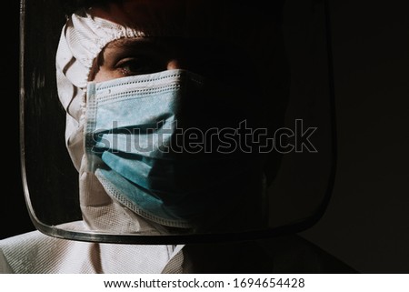 Female hero doctor with mask and face shield crying tear due to coronavirus covid-19 situation  Royalty-Free Stock Photo #1694654428