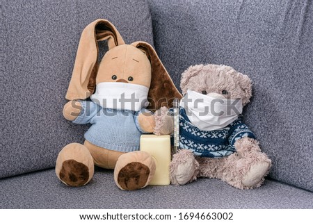Coronovirus outbreak in world. Wear medical masks and wash your hands more often. Soft toy bunny and bear in medical masks and soap in paws to protect against the virus.