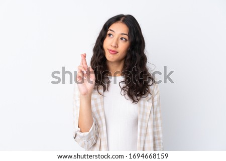 Mixed race woman over isolated white background with fingers crossing and wishing the best