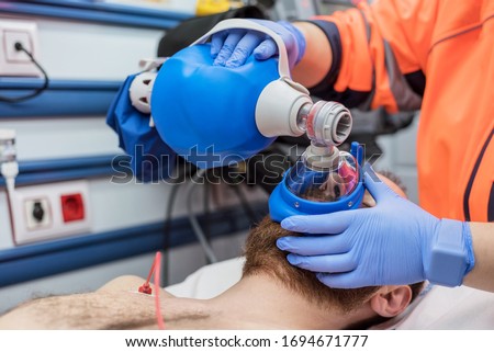 Covid-19 respiratory insufficiency. Urgency doctor using mask Ambu bag on a patient with pneumonia due to Coronavirus infection, for artificial ventilation . Royalty-Free Stock Photo #1694671777