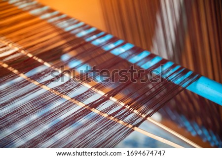 Silk threads and cocoons placed in a wooden basket Prepared for weaving into a large piece of silk Intentional And takes a long time to do Royalty-Free Stock Photo #1694674747
