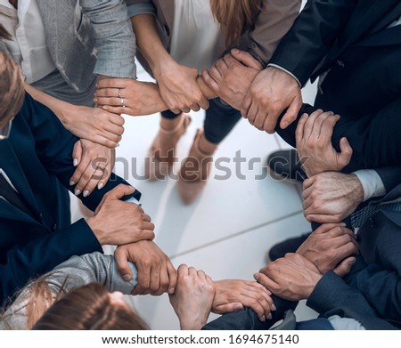 group of employees forming a circle out of hands