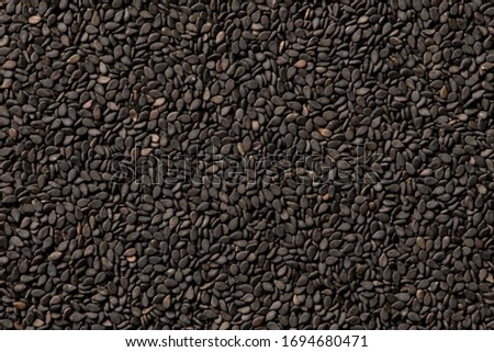 Black sesame seeds close up background Royalty-Free Stock Photo #1694680471