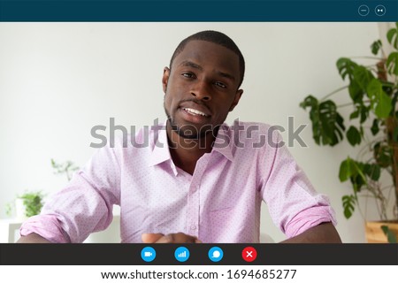 Computer screen webcam view African man pass job interview distantly by videoconference app. American english teacher teaches trainee via video call, easy and remote communication, modern tech concept Royalty-Free Stock Photo #1694685277