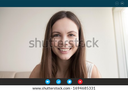 During self-isolation people contact with friends by videocall use videoconference app due to pandemic coronavirus outbreak. Young woman looks at webcam face view, video call e-date services concept Royalty-Free Stock Photo #1694685331
