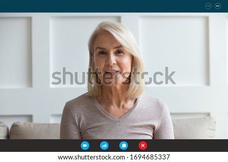 Head shot aged woman qualified psychologist looks at cam during psychological support session on-line counselling with client over telecommunication app. Chat via teleconference with relatives concept Royalty-Free Stock Photo #1694685337