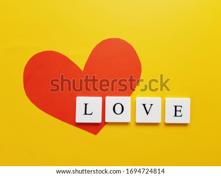 a red heart with LOVE word on yellow Background