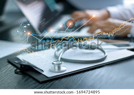 Healthcare business graph data and growth, Stethoscope with doctor's health report clipboard on table, Medical examination and doctor analyzing medical report on laptop screen.
 Royalty-Free Stock Photo #1694724895