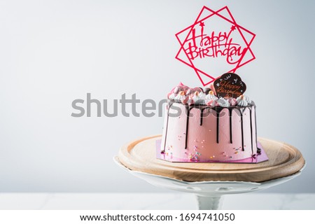 Pink Birthday cake and Happy birthday tag on birthday cake over light grey.food concept anniversary background.