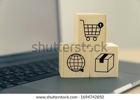 icon shopping cart and ecommerce on wooden blocks with laptop, concept online purchase.