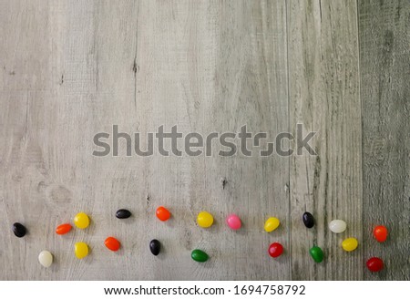 Easter background with copy space. Colorful jelly eggs on a wooden background.