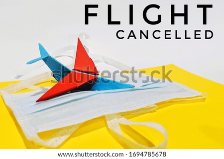Flight cancellation due to the impact of coronavirus (COVID-19) concept. Plane model and face mask with text flight cancelled. 