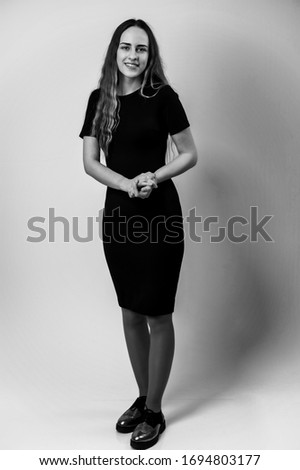 Photo on a white background pretty woman with a slim figure and long hair in a black dress with a smile talking