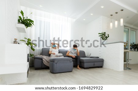 Young couple conflict sitting on a couch argue unhappy being in quarantine because of pandemic of covid 2019. Royalty-Free Stock Photo #1694829922